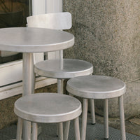 Metallic silver round table and stools with a sleek, minimalist design. Perfect for modern outdoor settings.