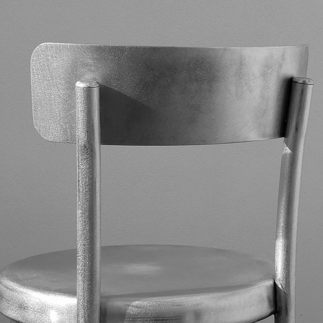 Metallic silver chair with a sleek, minimalist design and smooth finish. Modern style complements any decor.