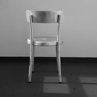 "Stylish silver metal chair with a sleek, minimalist design against a neutral background."