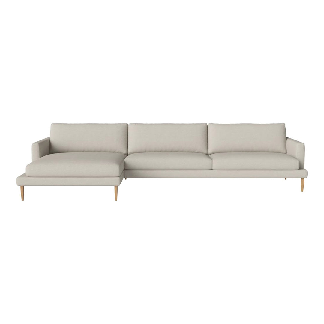 Light beige sectional sofa with soft cushions and minimalist design, featuring natural wood legs for a cozy look.
