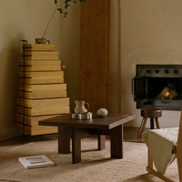 Wooden coffee table with dark brown finish, beige accents, and earthy tones in a cozy, minimalist living space.