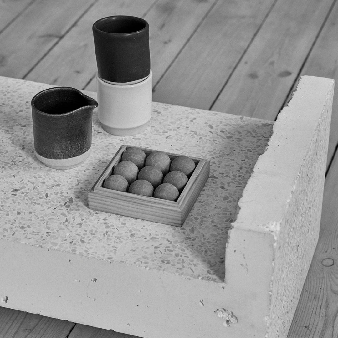 Stylish black and white ceramics on a textured concrete surface, featuring circular patterns and minimalist design.