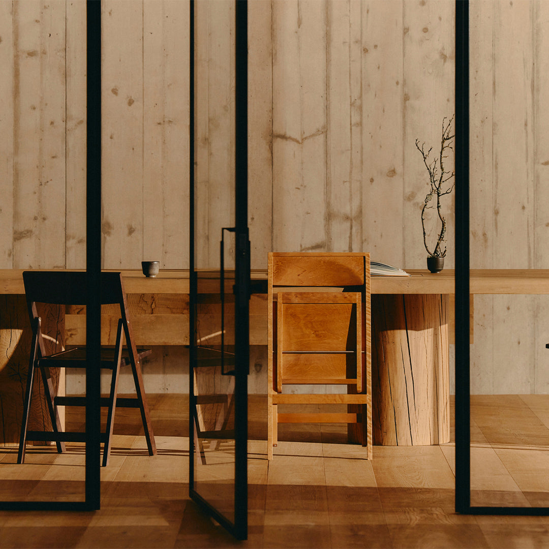 "Natural wood textures in warm tones, contrasted with sleek black frames and minimalist design elements."