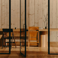 "Natural wood textures in warm tones, contrasted with sleek black frames and minimalist design elements."