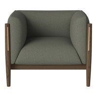 Green upholstered armchair with smooth, rounded cushions and wooden accents. Modern design with a minimalist aesthetic.