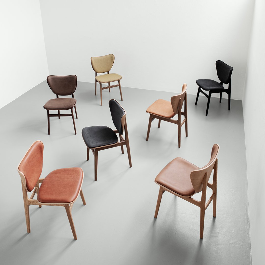 Set of eight stylish chairs in earthy tones: rust, beige, black, and brown, featuring smooth and textured fabric patterns.