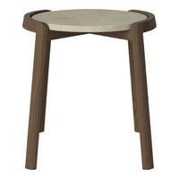 Round stone top side table with dark wood legs, featuring a minimalist design and smooth finishes.