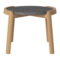 Round black marble table top with natural wood legs, featuring smooth edges and a modern design.