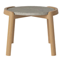 Light wood legs support a round gray concrete top, featuring a minimalistic, contemporary design.