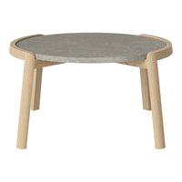 Round coffee table with a gray top and natural wood legs, featuring a minimalist design and smooth finish.