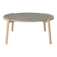 Round coffee table with a gray stone top and natural wood legs, featuring a sleek, minimalist design.
