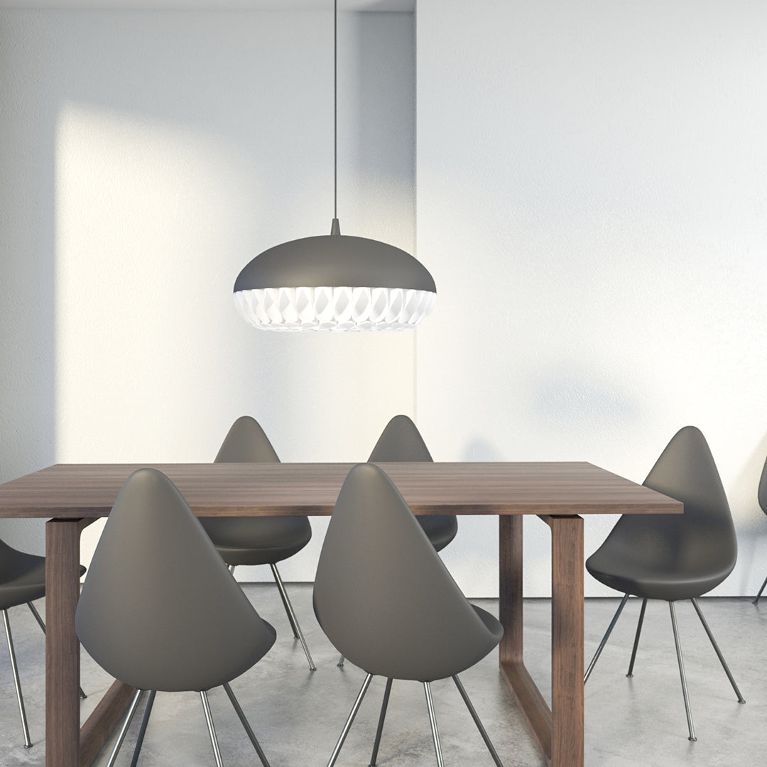 Gray pendant light over a minimalist wooden table with rounded gray chairs, set against a bright, clean backdrop.