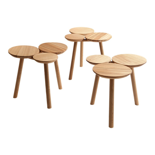 Set of three light wooden stools with circular tops and slender legs, showcasing a natural wood grain pattern.