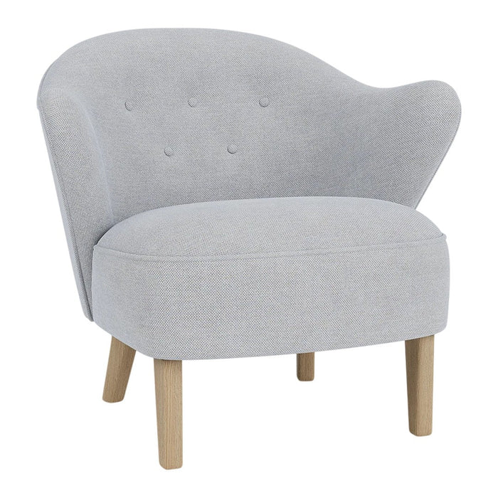 Light gray upholstered chair with subtle button tufting and natural wood legs, featuring a curved back design.