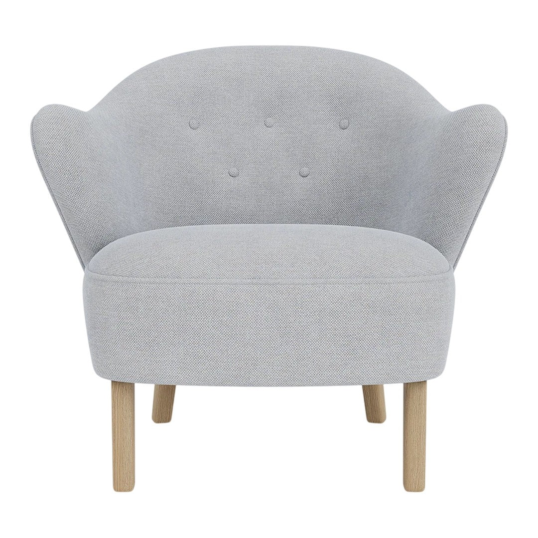 Stylish light gray chair with a curved back, button detailing, and natural wooden legs. Modern and cozy design.