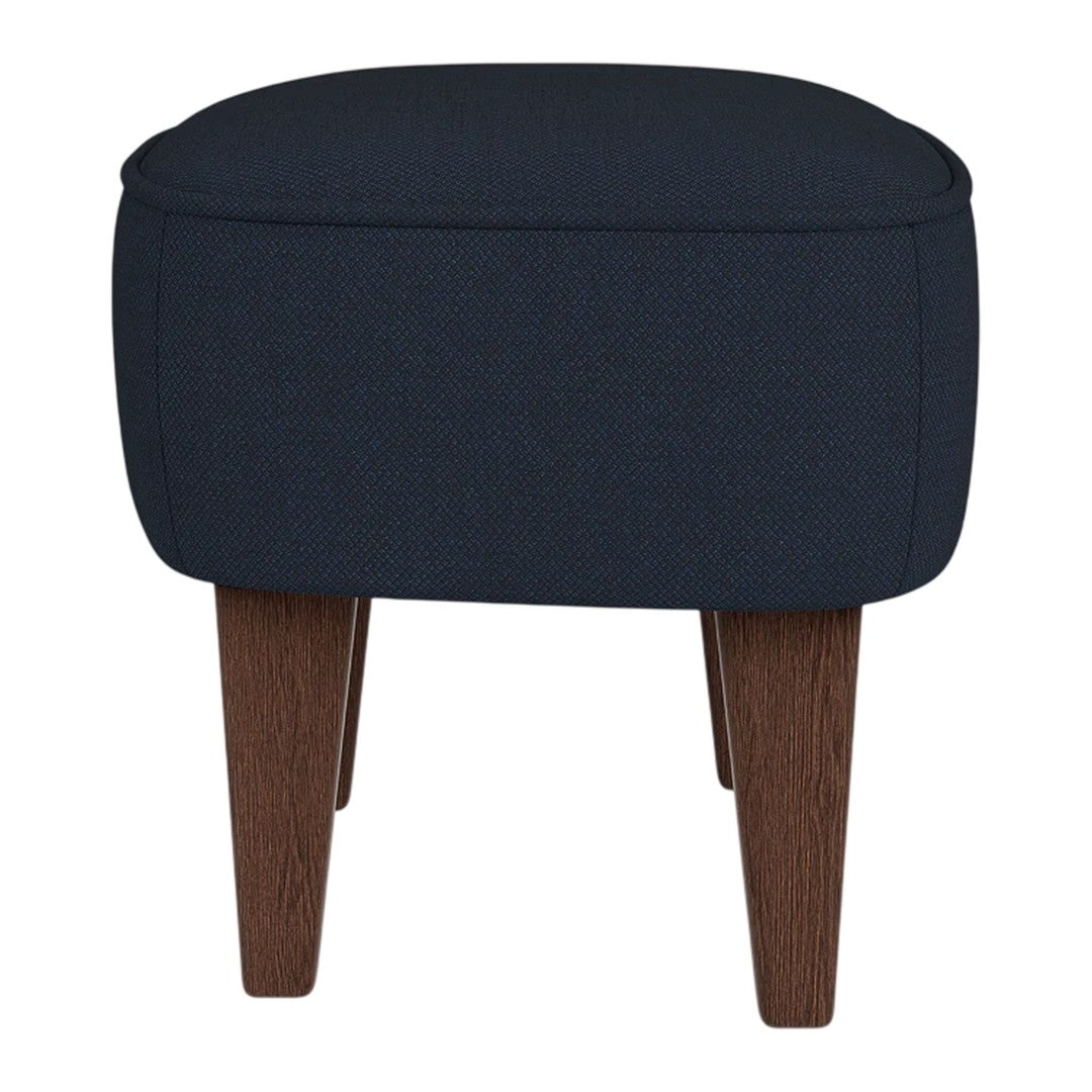 Navy blue upholstered ottoman with clean lines and dark wood legs, perfect for modern decor.