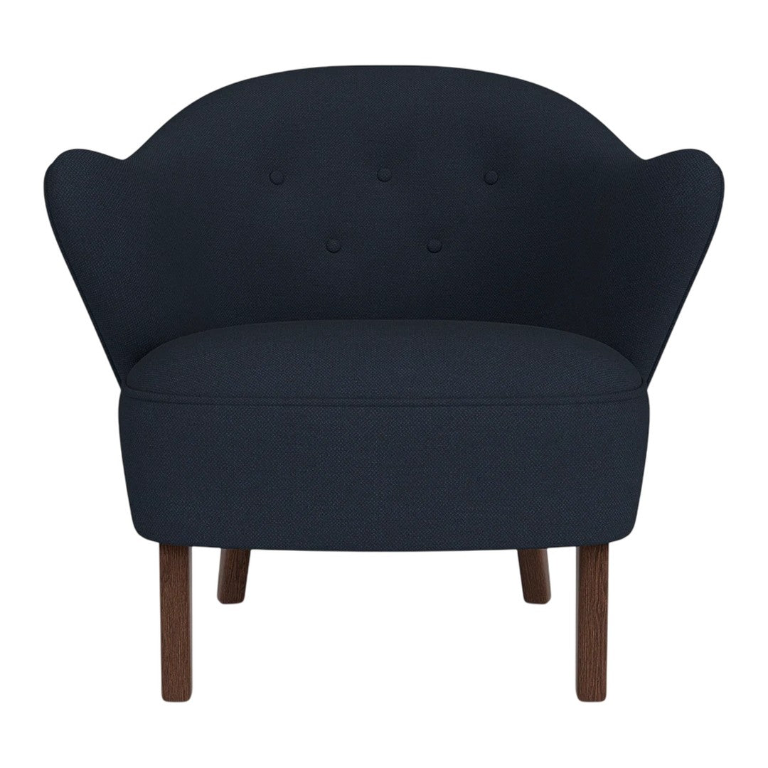 Navy blue upholstered chair with button-tufted back and wooden legs, featuring a sleek, modern design.