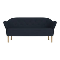 Navy blue tufted sofa with curved backrest and light wooden legs. Elegant, minimalist design for modern interiors.