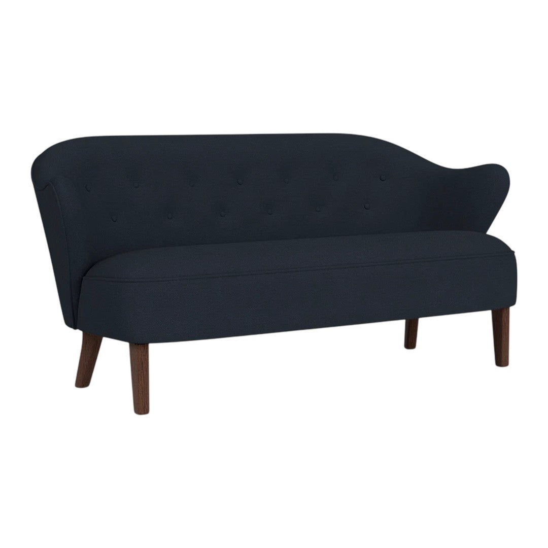 Navy blue sofa with a tufted fabric design and sleek wooden legs, featuring a stylish curved backrest.