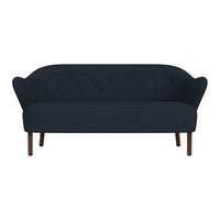 Deep navy blue tufted sofa with smooth upholstery and elegant curved arms, featuring wooden legs. Perfect for modern decor.