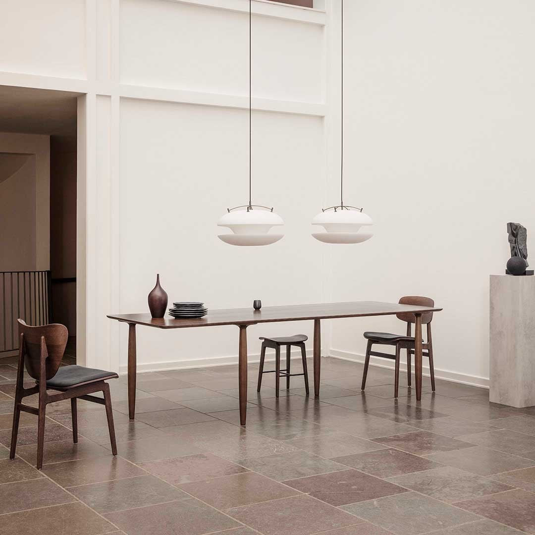 Modern dining room featuring warm wood tones, minimalist white lighting, and earthy, textured floor patterns.