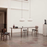 Modern dining room featuring warm wood tones, minimalist white lighting, and earthy, textured floor patterns.