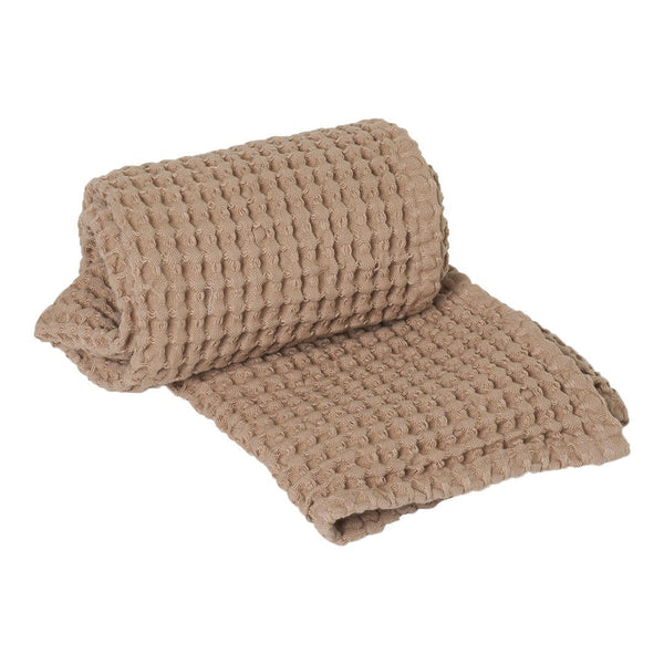 Soft beige waffle weave blanket, showcasing a textured grid pattern with rolled edge detail. Ideal for cozy decor.