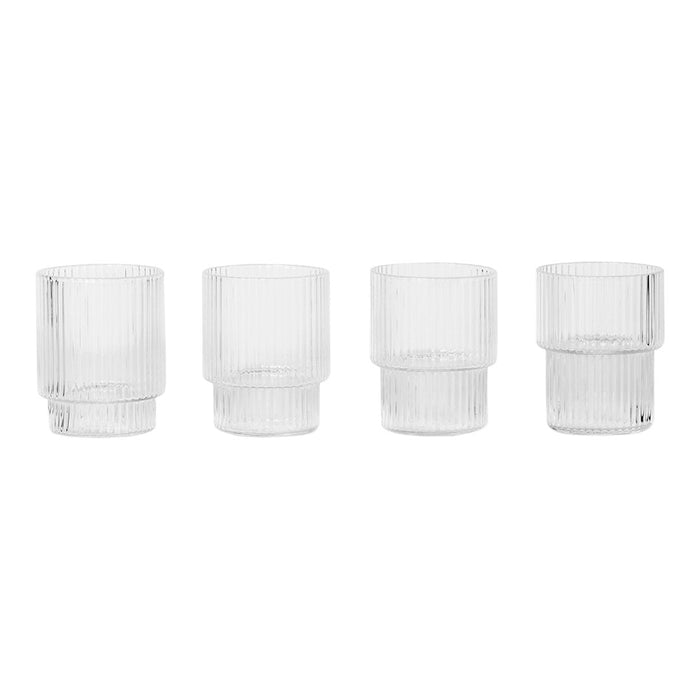 Set of four clear glass tumblers with vertical ribbed patterns, showcasing a modern, minimalist design.