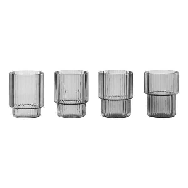 Set of four transparent gray ribbed glasses with varying heights and widths, showcasing modern, textured design.