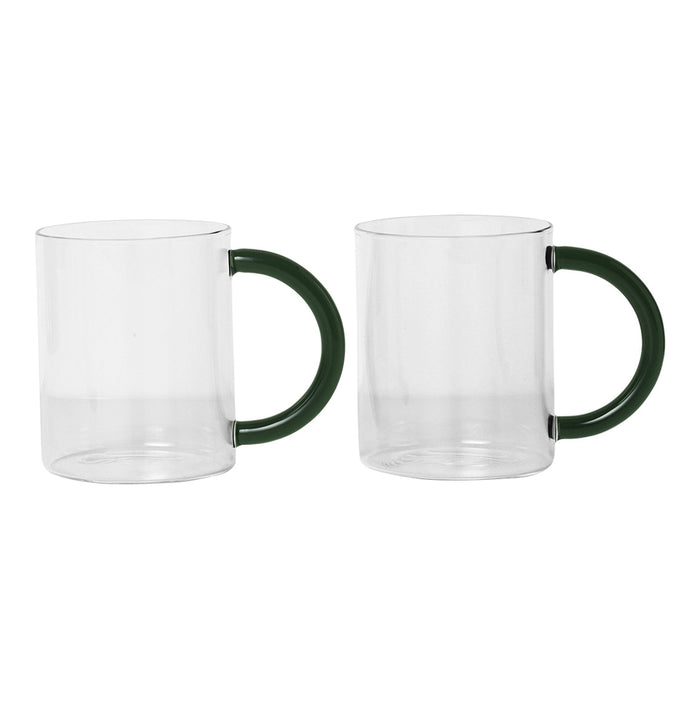 Clear glass mugs with green handles, featuring a sleek, modern design and seamless transparency.