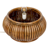 Brown woven rattan lamp base with ribbed texture and a vintage-style light bulb. Warm, natural aesthetic.