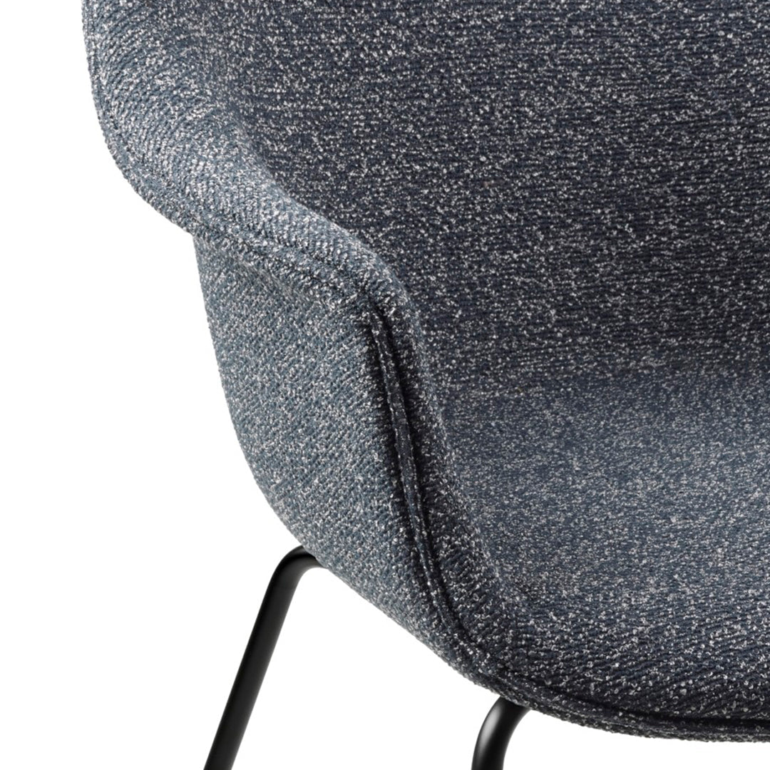 Textured dark blue upholstery with speckles, complemented by sleek black metal legs. Stylish and modern design.