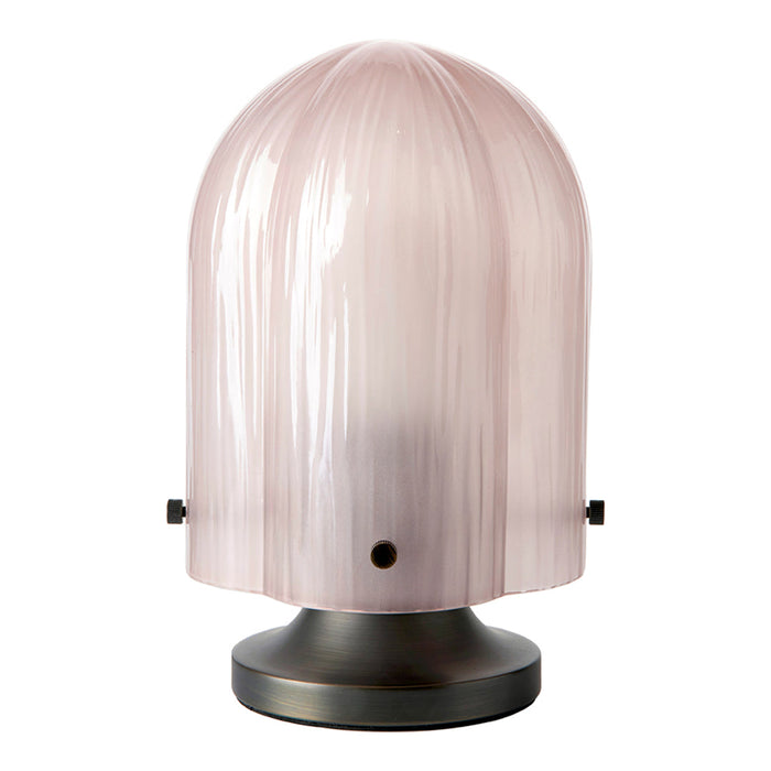 Soft pink glass lamp with a ribbed pattern and a sleek black base, adding a modern touch to any decor.
