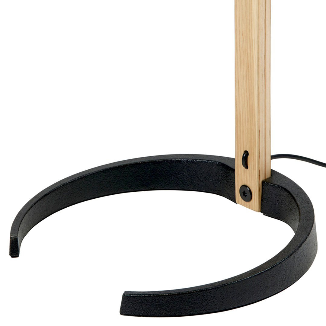 Black and natural wood floor lamp base with a smooth curved design. Minimalist, modern aesthetic.
