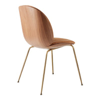 Wooden chair with a natural finish and sleek gold legs, showcasing minimalist design and smooth contours.