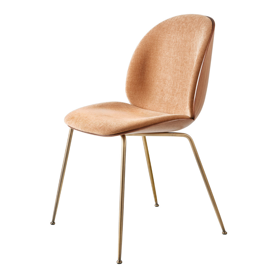 Mid-century modern chair with a soft peach fabric seat and sleek golden legs, featuring a minimalist design.