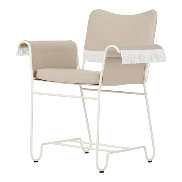 Beige upholstered chair with white fringe accents and a sleek white metal frame, perfect for modern decor.
