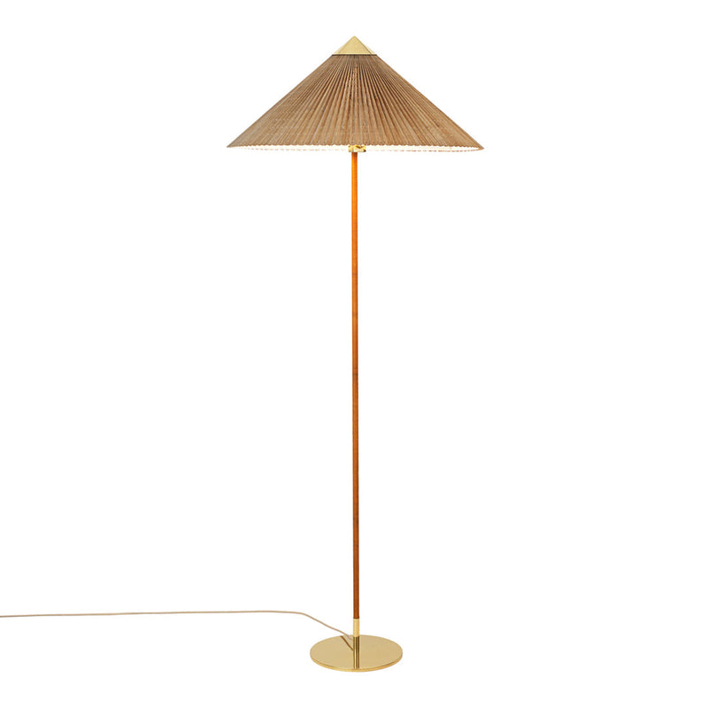 Gold metal floor lamp with a natural woven shade, featuring a sleek, modern design and a minimalist aesthetic.