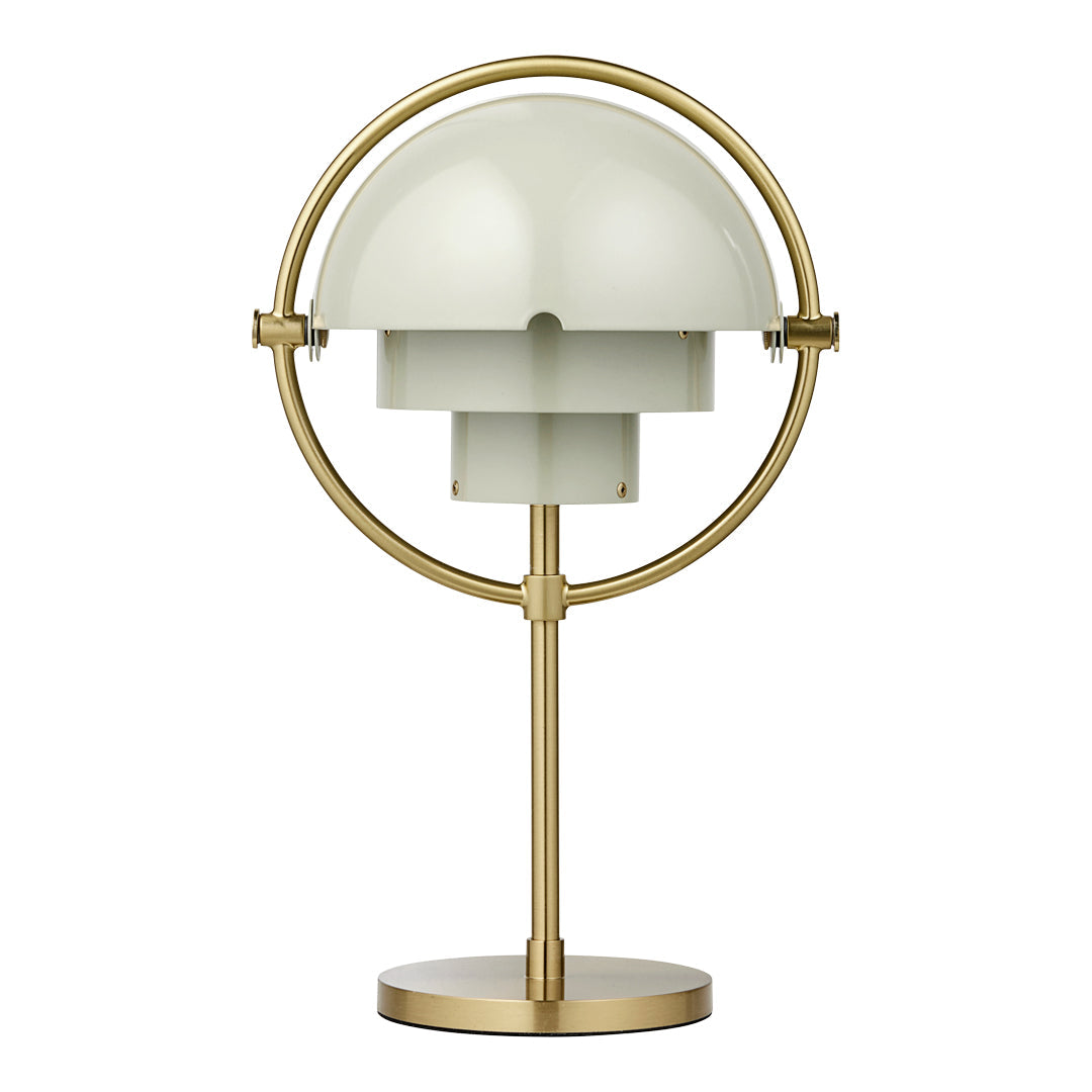 Gold-finished lamp with a round base and a soft green dome shade, featuring sleek, modern lines.