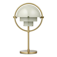 Gold-finished lamp with a round base and a soft green dome shade, featuring sleek, modern lines.