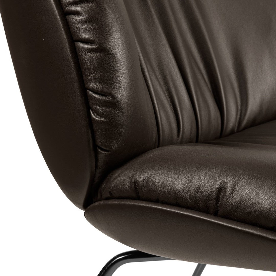 Brown leather chair with soft, textured surface and elegant draping pattern. Ideal for stylish decor.
