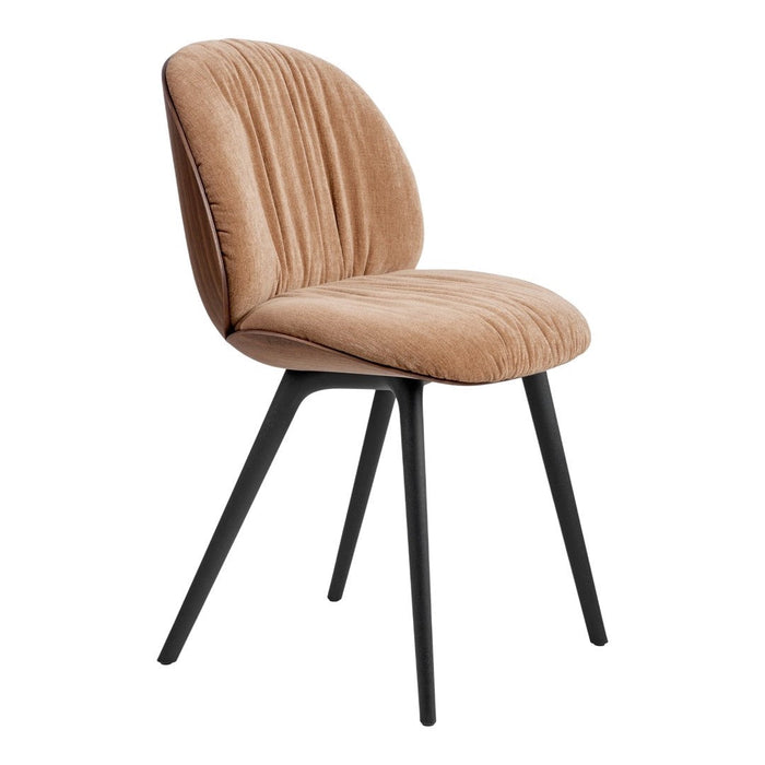 Velvet chair in warm beige with ribbed texture and sleek black legs, perfect for modern decor.