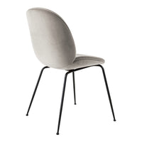 Soft gray velvet chair with smooth curves and sleek black metal legs, perfect for modern decor.