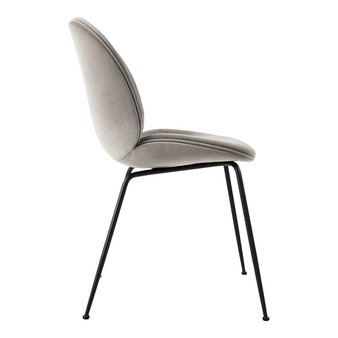 Gray velvet chair with smooth upholstery and sleek black metal legs, featuring a minimalist design.