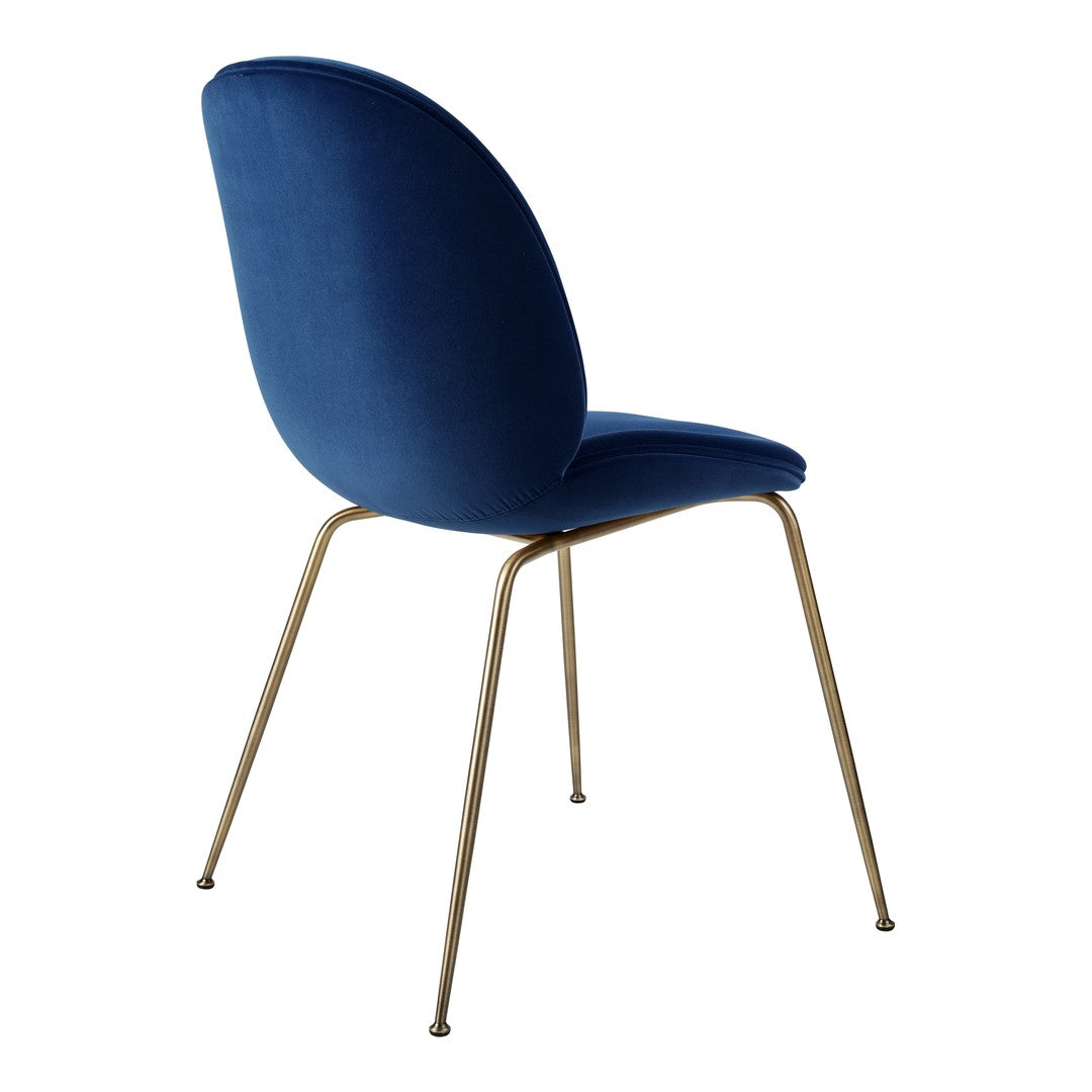 Velvet blue dining chair with sleek gold legs, showcasing a modern and minimalist design. Perfect for elegant spaces.