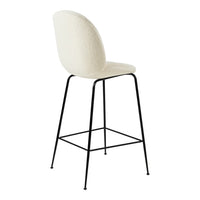 Cream upholstered bar stool with a sleek black metal frame. Elegant textured finish for a modern touch.