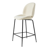 Beige upholstered stool with curved back and black metal legs. Clean, modern design enhances any space.