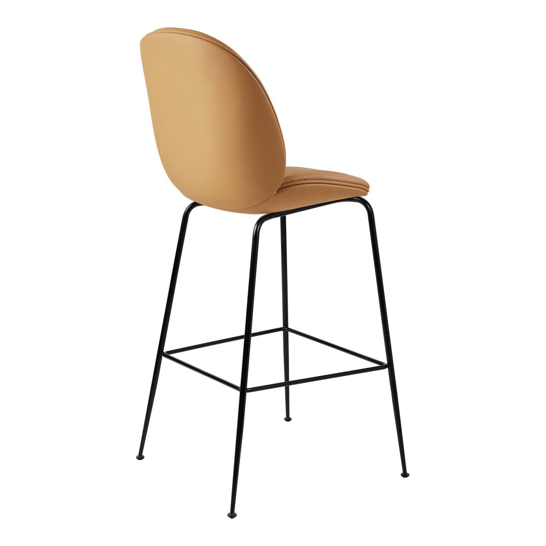 Tan upholstered bar stool with a curved back and black metal legs. Modern and sleek design for any decor.
