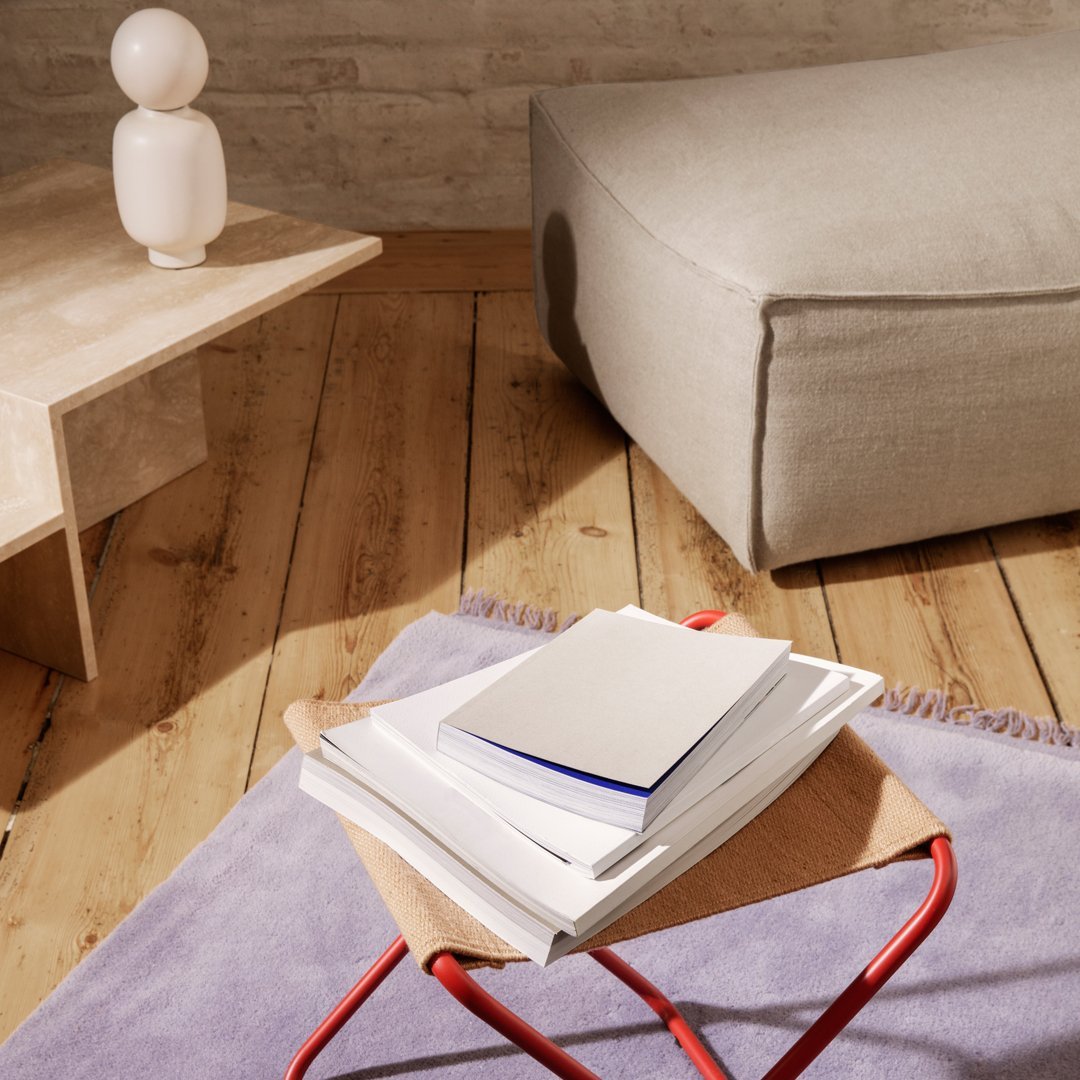 "Soft lavender rug with natural wood flooring, featuring beige and light gray accents in modern decor."