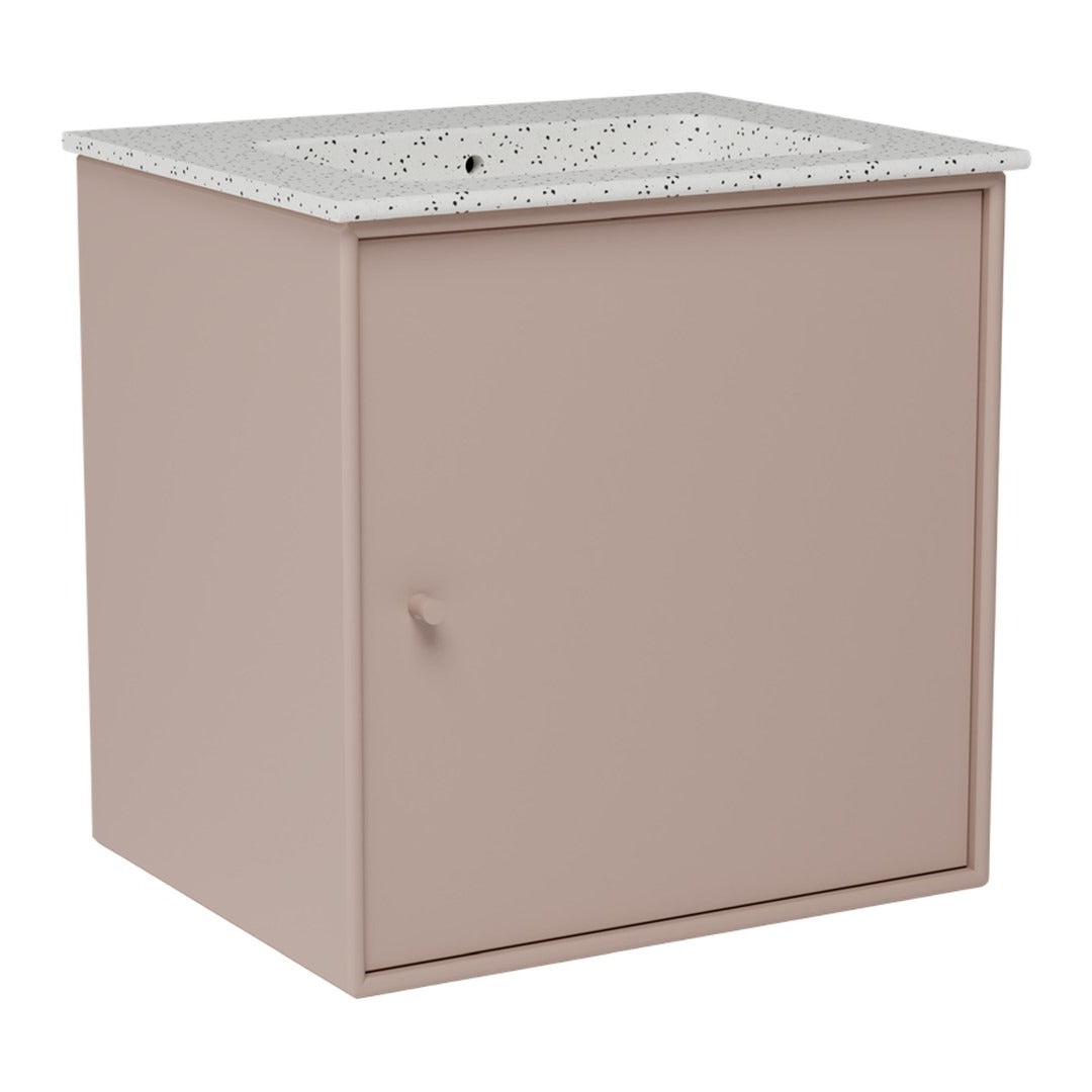 Blush pink vanity cabinet with a speckled white countertop. Modern minimalist design.